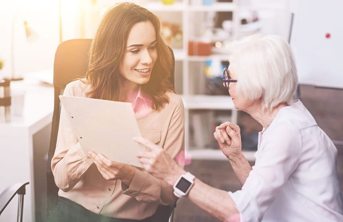 A clinician and client reviewing a care plan together in a warm, sunlit office